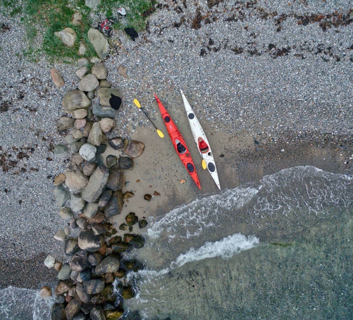 Dronefoto af to kajaker på en strand